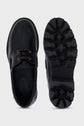 Top and bottom view of a black leather lace-up shoe with a thick, rugged semelle crantée, red and brown laces, and visible stitching details on a plain light background.