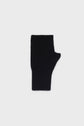 A single black fingerless glove, reminiscent of mitaines noir, is laid flat on a plain light gray background, with the thumb section visible and the other fingers openings not shown—a subtle yet practical choice among accessoires hiver.