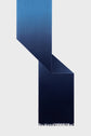 A blue gradient scarf, or écharpe bleu, with fringed ends is draped in a geometric, angular arrangement against a light gray background, creating sharp shadows and shapes.