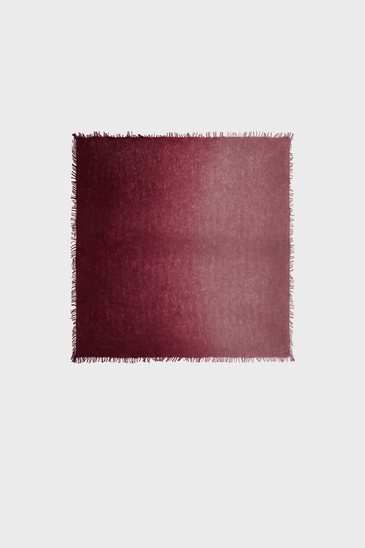 A rectangular maroon rug with a subtle gradient from dark to light and short fringe along the edges, reminiscent of the elegant tones found in an echarpe bordeaux or echarpe cachemire, displayed on a plain white background.