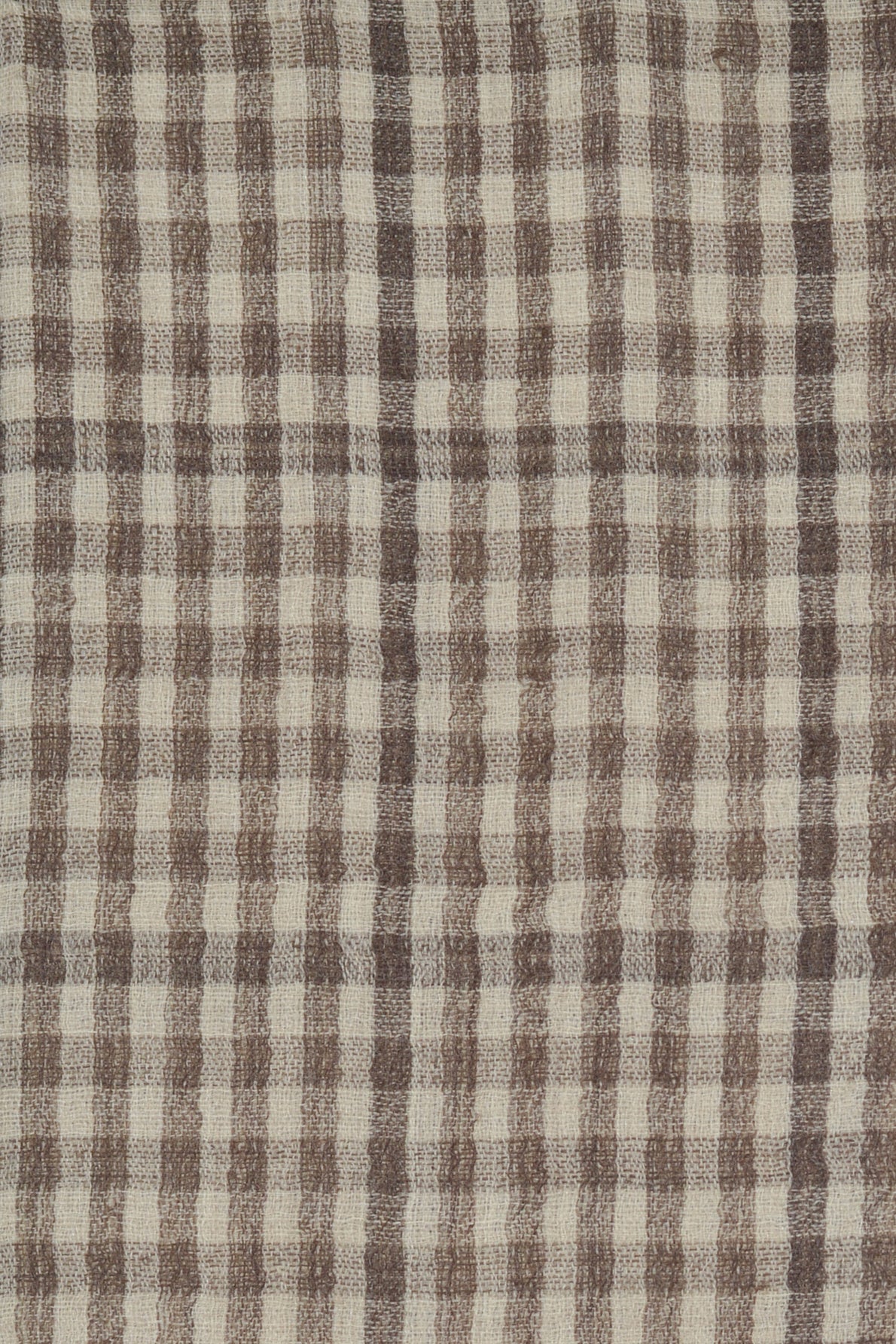 A close-up of a textured fabric with a brown and beige checkered pattern, featuring evenly spaced vertical and horizontal lines. This elegant écharpe à carreaux is crafted from a luxurious blend of laine soie cachemire, offering both warmth and sophistication.