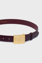 A ceinture élégante in burgundy leather, this belt features a square, gold-toned buckle engraved with DAREL, while GERARD DAREL is printed on the inside. This ceinture cuir is the perfect accessoire mode to elevate any outfit. The background is white.