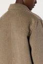 Close-up of a person wearing a beige manteau laine, shown from the back and side. Only the neck, shoulder, and upper back of the manteau mi-long are visible against a plain background.