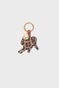 Leopard-print animal-shaped keychain with a gold key ring and a small gold charm attached, featuring a brown leather accent—this playful porte-clé panthère adds a fun touch to your everyday essentials. Crafted in toile enduite léopard, it’s the perfect charm de sac for those who love a hint of wild style.