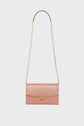 A light pink pochette enveloppe cuir with a gold chain strap and a gold clasp, photographed against a white background—an accessoire tendance that adds elegance to any outfit.
