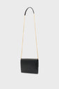 A black rectangular sac bandoulière femme with a long gold chain strap and a leather shoulder pad, displayed against a plain light gray background. This accessoire tendance effortlessly combines elegance and functionality for any occasion.
