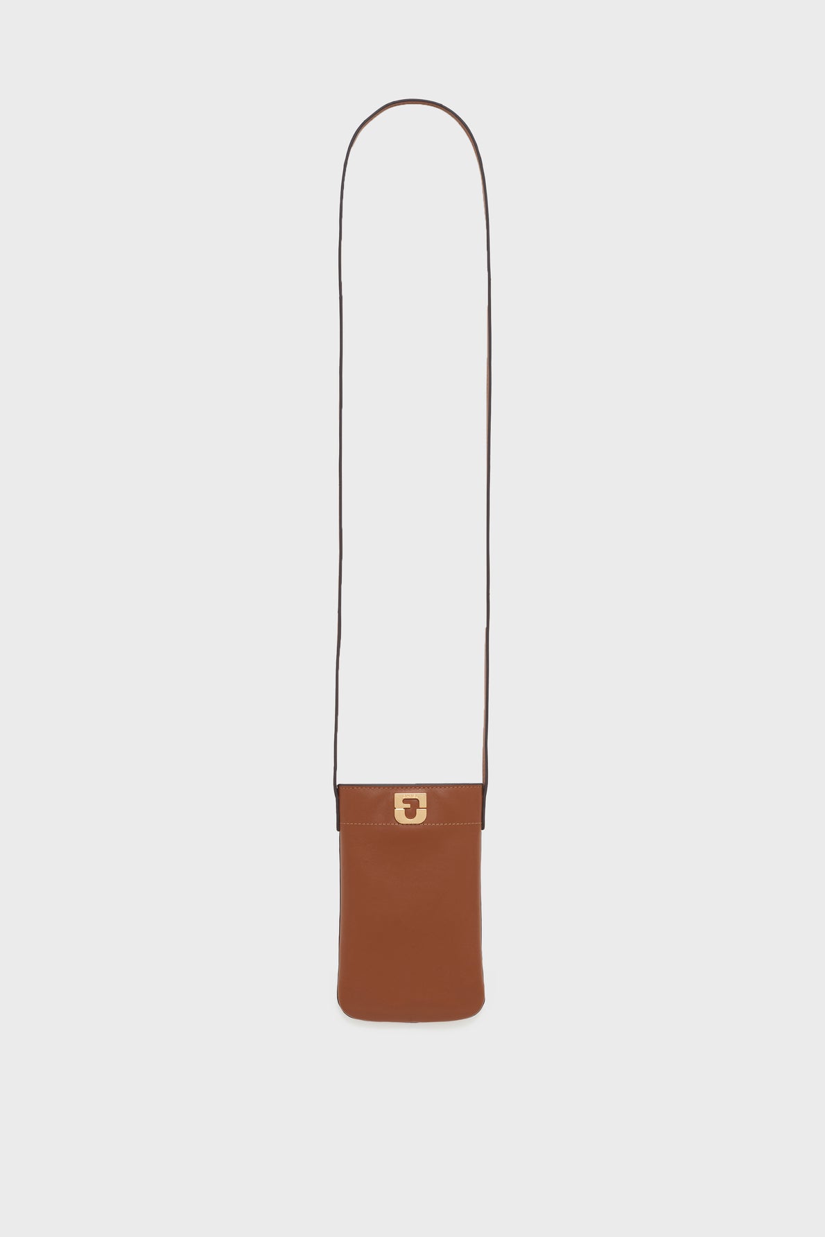 A small, rectangular brown leather sac bandoulière with a long, thin strap and a gold clasp on the front, this porte-téléphone cuir is the perfect accessoire tendance, displayed against a plain white background.