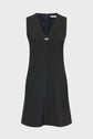 Sleeveless black dress (robe sans manches) with a deep V-neckline, front seam detail, and a small decorative brooch at the center of the chest. This robe noire features a simple, A-line silhouette and a zipper closure at the back.