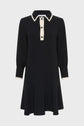 Black long-sleeve robe col chemise with a flared skirt, cream-colored collar, button placket, and cuffs. This robe courte chic features two chest pockets and contrast trim details. Displayed on a plain white background.
