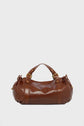 A brown cuir froissé leather sac à main with gold hardware, double handles, and side straps, resting against a plain white background.