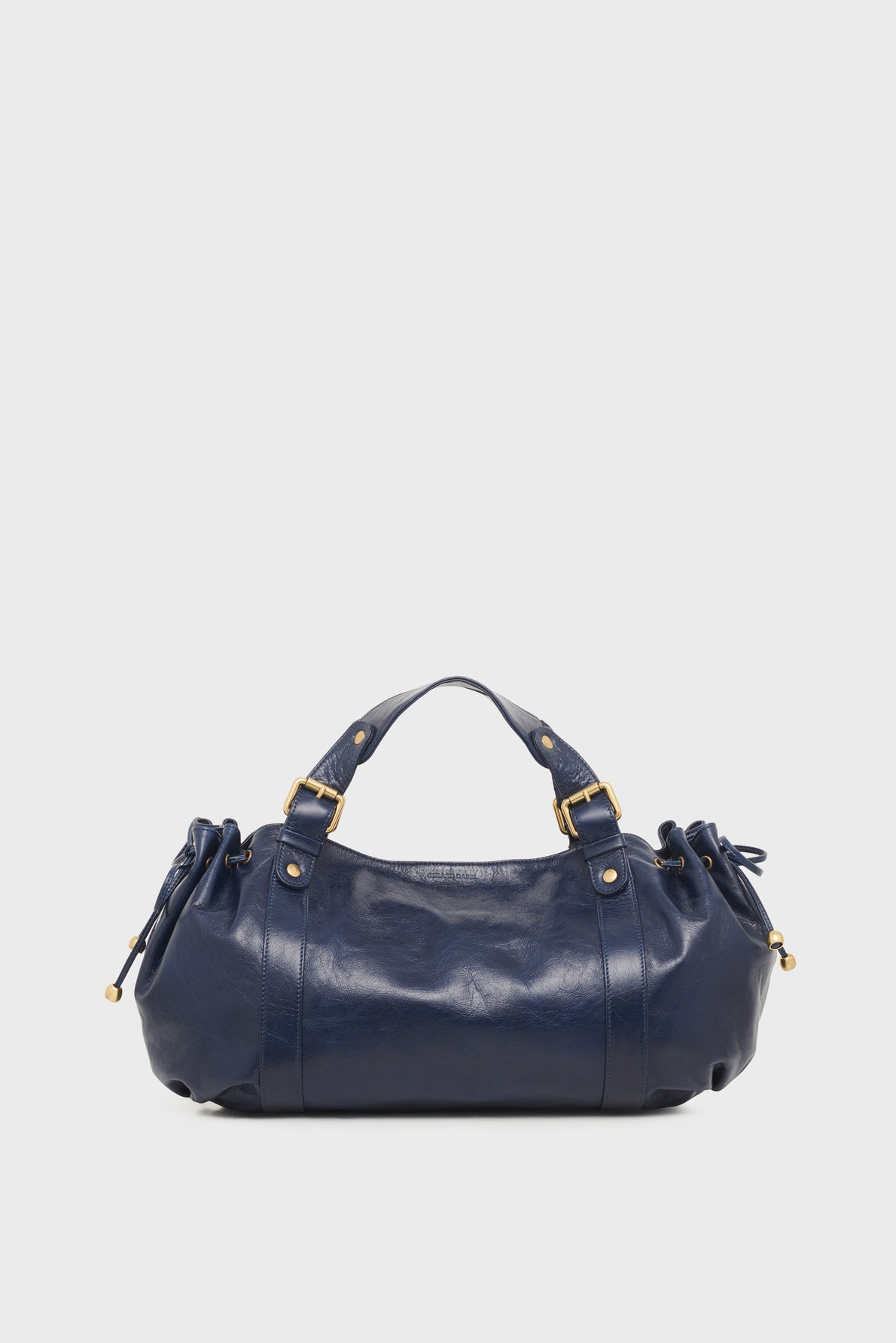 A navy blue leather sac à main cuir by Vanessa Bruno with gold hardware, short handles, and ruched side details, displayed against a plain white background.