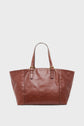 A large brown cabas cuir with two adjustable shoulder straps and gold buckle details, this sac porté épaule is displayed against a plain white background.