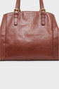 Brown leather sac à main chic with gold hardware and two top handles, photographed against a plain white background.