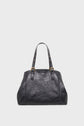 Black leather handbag with two shoulder straps featuring gold-tone hardware and stud accents, set against a plain white background. Inspired by sac inspiration 70’s style, this cabas cuir boasts a structured yet slightly slouchy shape, perfectly blending retro elegance with modern chic.