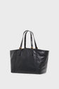Large black leather tote bag with double handles, gold buckle accents, and small gold studs on the straps, this cabas cuir is photographed against a plain white background. The design brings a subtle sac inspiration 70’s touch for a truly timeless sac à main chic.