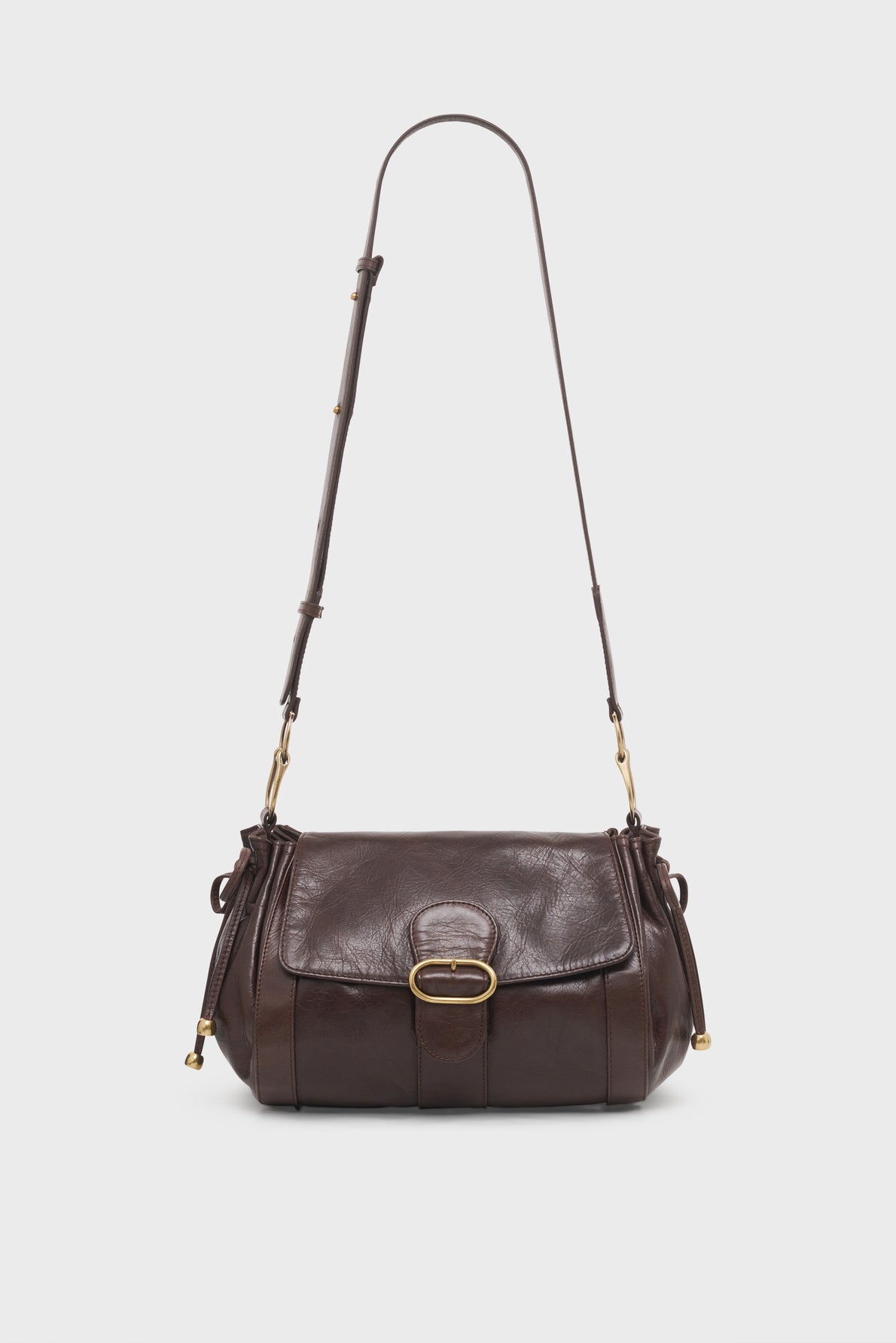 A dark brown leather sac bandoulière with a flap closure, gold buckle detail, and an adjustable shoulder strap. The bag has a classic, structured design and gold hardware accents.