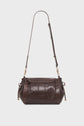 A dark brown leather sac bandoulière with gold hardware, drawstring sides, flap closure, and an adjustable strap, displayed against a plain white background.