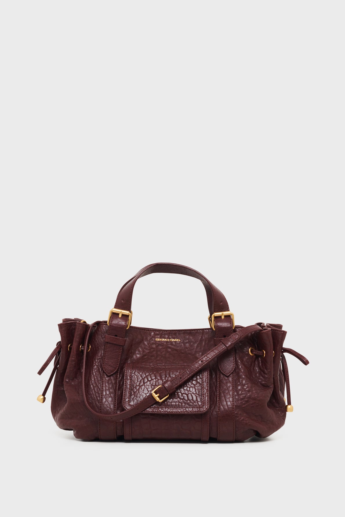 A dark brown leather sac à main with gold hardware, two top handles, a front pocket, side drawstring details, and an adjustable shoulder strap, displayed against a plain white background. This elegant sac 18H design combines timeless style with contemporary functionality.