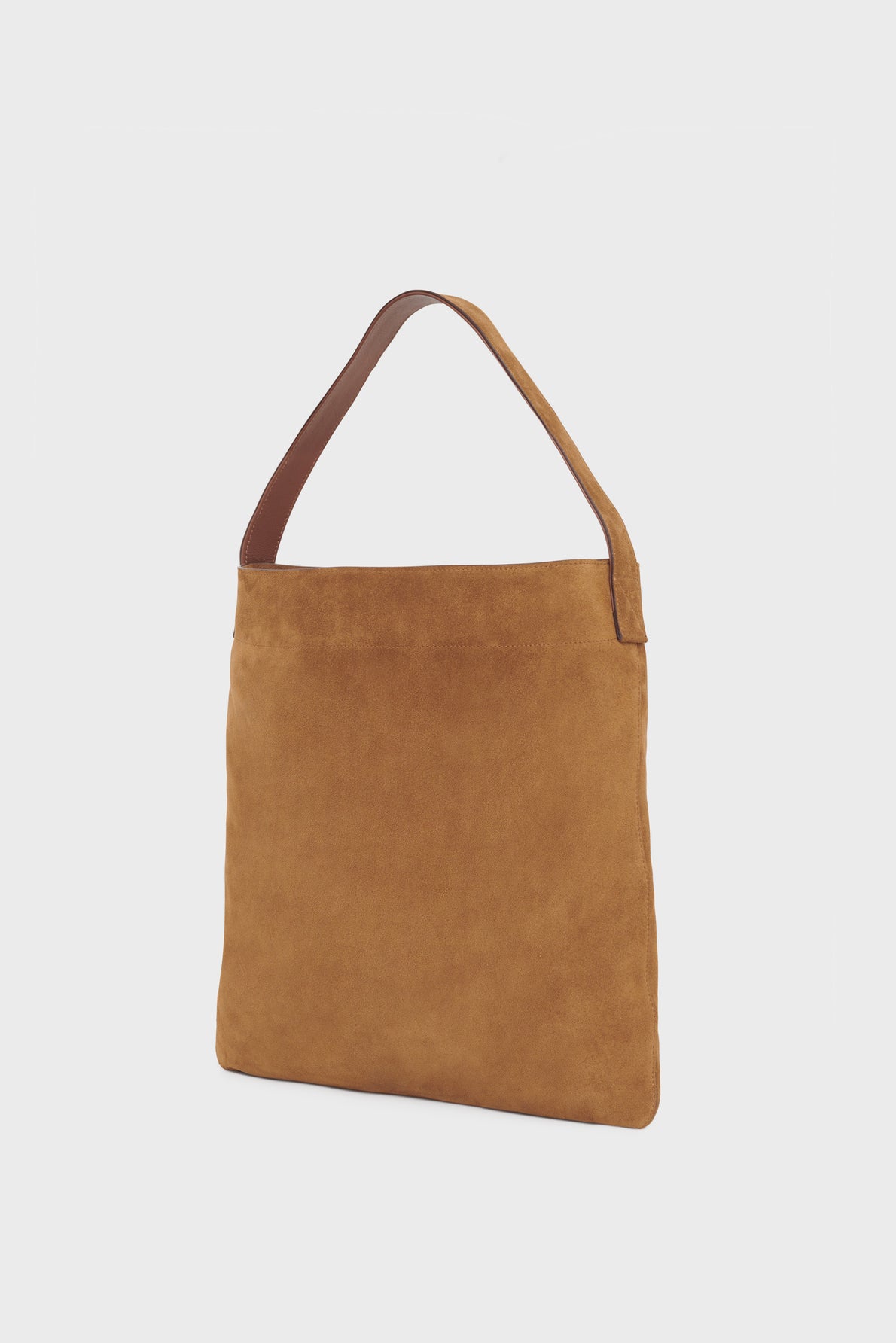 A brown suede totebag crafted in cuir velours, featuring a single wide strap and displayed against a plain white background. The bag has a simple, rectangular shape and a minimalist design.
