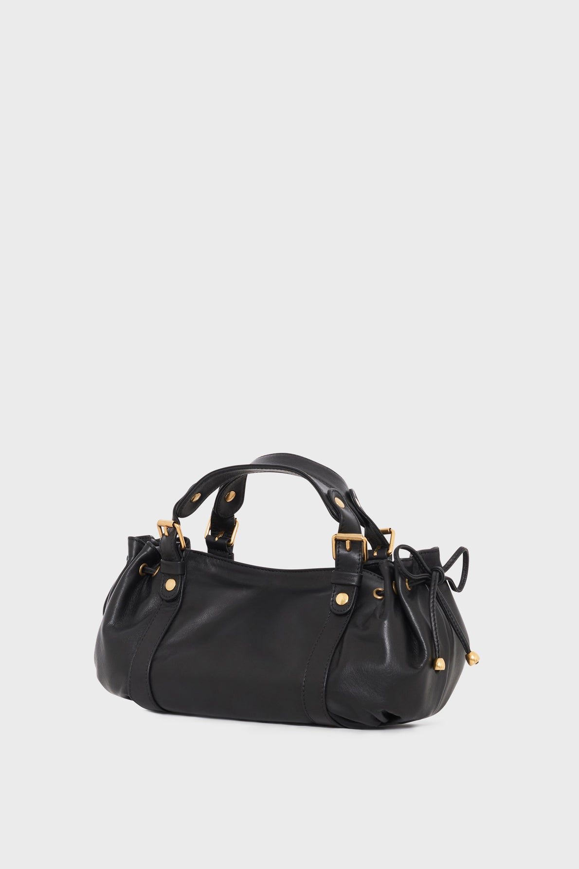 A black cuir leather sac à main with gold hardware, short double handles, and side drawstring accents, displayed against a plain light gray background.