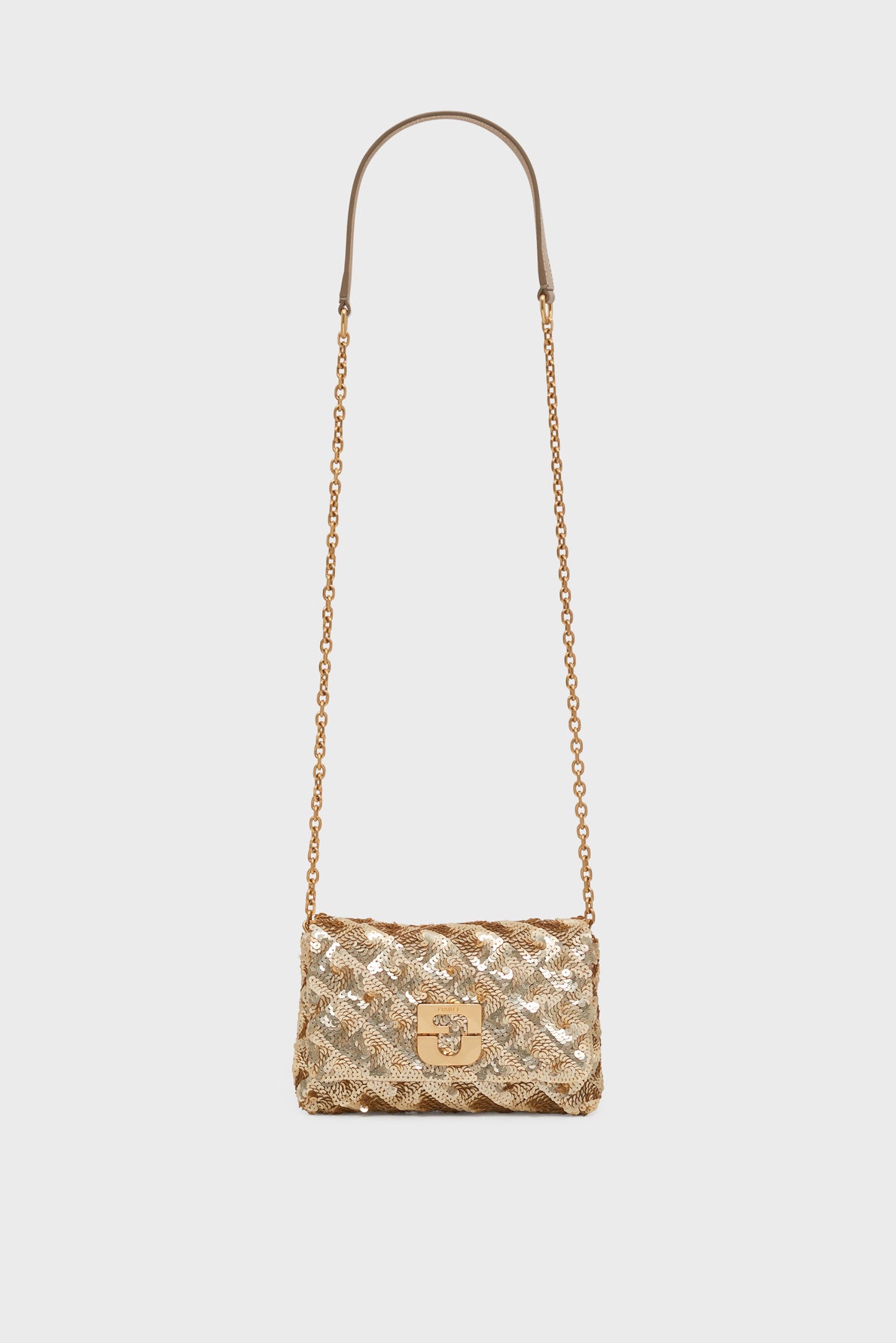 A gold quilted sac bandoulière with a chain strap, metallic sheen, and a front clasp closure, displayed against a plain light gray background—an elegant pièce de créateur that brings sophistication to any ensemble.