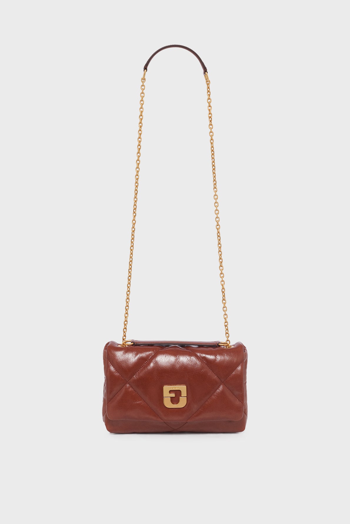 Brown quilted leather sac bandoulière with a gold chain strap and a gold clasp, displayed against a plain white background. This elegant piece showcases the timeless style of a créateur, crafted in luxurious cuir for a sophisticated finishing touch.