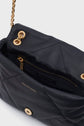 Black quilted Gerard Darel sac bandoulière in luxurious cuir d’agneau, featuring a gold chain strap, gold button clasp, and an open view revealing a zippered interior pocket and branded lining—a true pièce de créateur.