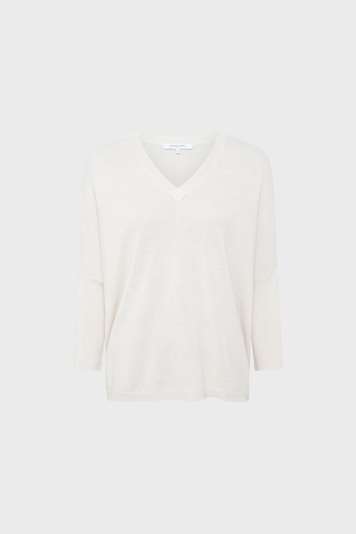 A plain, off-white, V-neck sweater with three-quarter length sleeves is displayed against a light gray background.