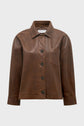 Brown leather jacket with a collar, button-down front, single chest pocket, and long sleeves, displayed on a plain light gray background—a versatile veste courte marron that perfectly blends the style of a surchemise cuir for a chic and modern look.