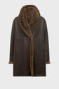 Dark brown, knee-length manteau cuir mouton featuring a wide, plush shearling collar and matching shearling trim on the cuffs and inner edge. This manteau peau lainée boasts a smooth leather-like exterior and an elegant open-front design.