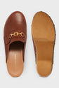 A pair of brown leather sabots cognac slip-on clogs with gold-tone decorative mors siglés buckle detail. One shoe is shown from the top, displaying the insole and brand name; the other is shown from the bottom, revealing the sole and distinctive talon bois.