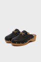 A pair of sabots noirs in black leather with gold chain detail and wooden platform soles, accented by gold studs along the sides, displayed on a plain light background. These clogs feature distinctive talon en bois for an elevated finish.