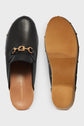 A pair of black leather slip-on loafers with gold mors siglés buckle detail and tan soles, shown from the top and the bottom. The insole is branded Gerard Darel.