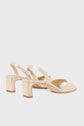 A pair of sandales cuir doré with block heels, open toes, and curved straps offers an effortlessly chic look, ideal for special occasions. These sandales élégantes are displayed against a plain white background.