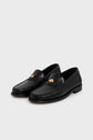 Pair of mocassins noirs cuir with stitching details and a small gold emblem on the upper front, displayed on a plain light gray background. These mocassins femme élégants effortlessly combine classic style with modern sophistication.