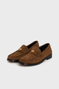 A pair of mocassins femme camel in brown suede with decorative stitching, low black heels, and a gold emblem detail on the front, these mocassins cuir velours exemplify chaussures casual chic when elegantly displayed on a white background.