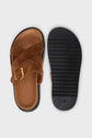 A pair of brown sandales camel with crisscross suede straps and gold buckles. One sandal is shown from the top, while the other displays its black textured sole, highlighting the comfortable design of these sandales plates in cuir velours.