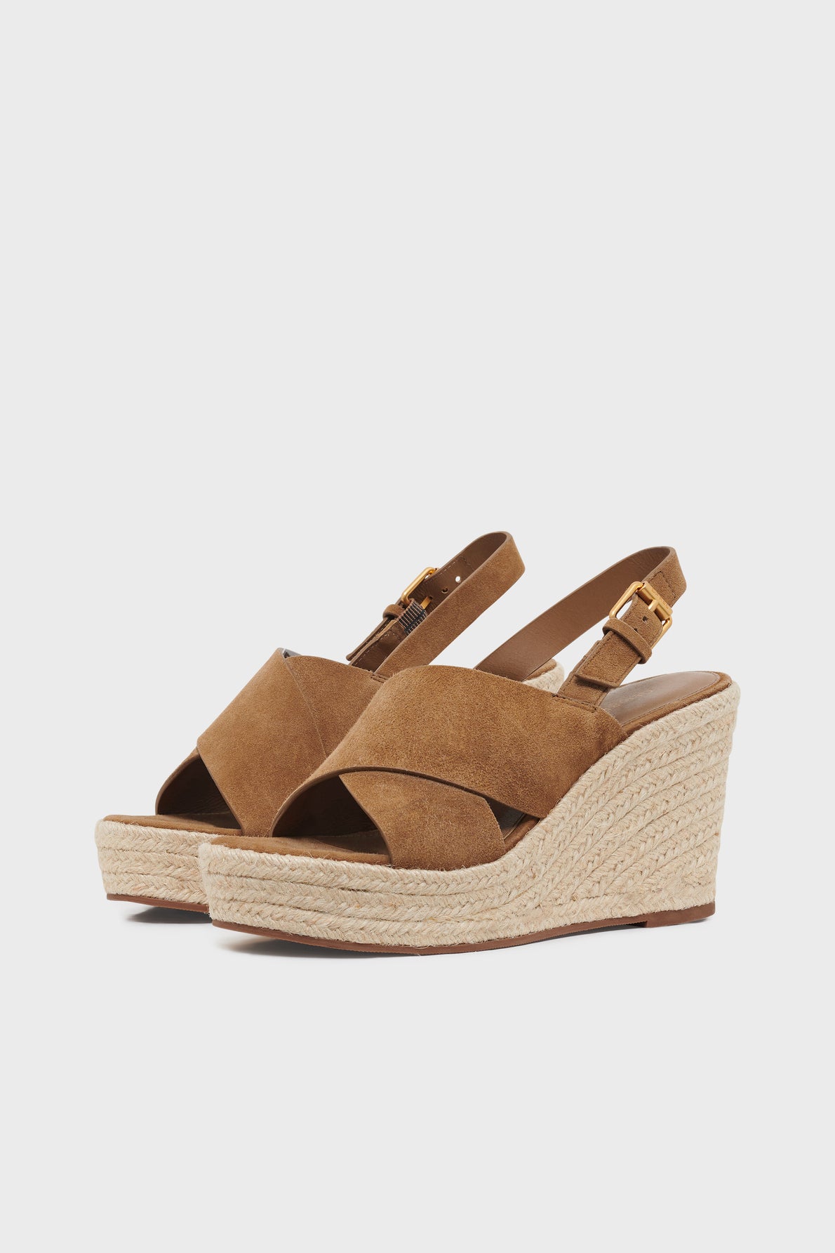 Brown suede wedge sandals with crisscross straps, ankle buckle closure, and espadrille-style woven platform soles, shown on a plain white background.