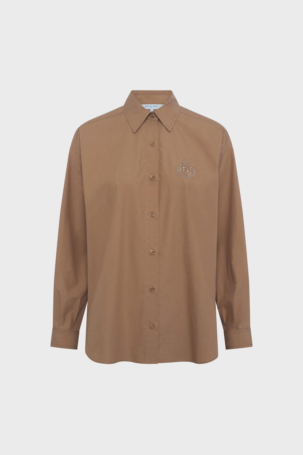 A long-sleeved, brown button-up shirt with a collar and an embroidered logo on the left chest, crafted from soft chemise coton popeline camel, displayed against a plain white background.