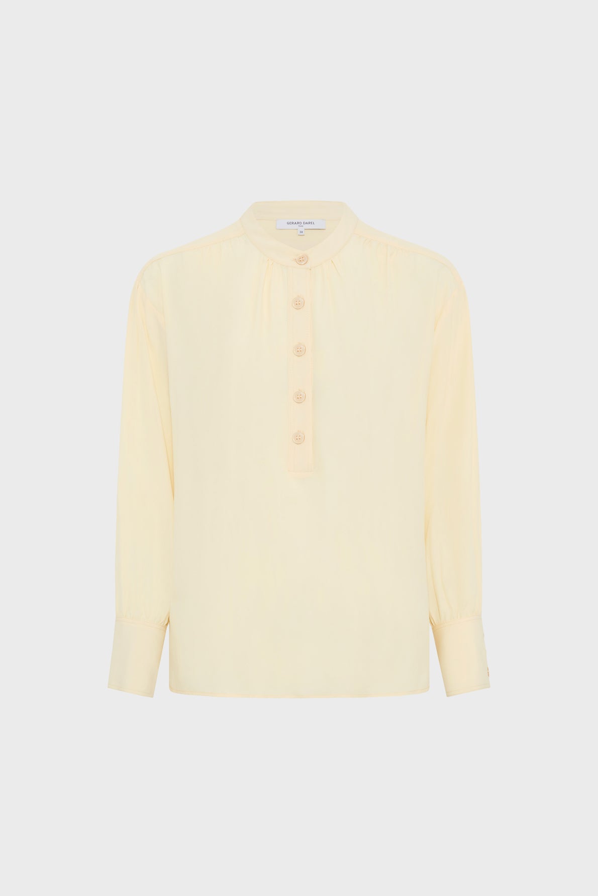 Light yellow blouse jaune in crêpe soie, featuring elegant manches bouffantes with long sleeves, a round collar, front button placket with four buttons, and buttoned cuffs, displayed on a plain white background.
