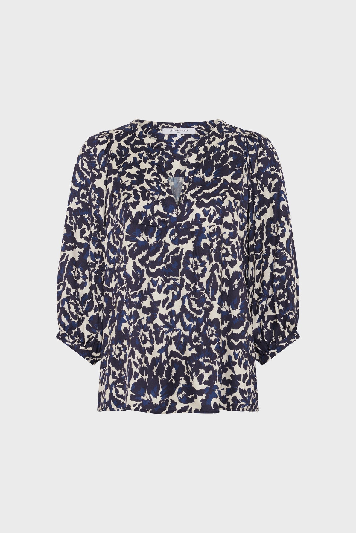 A womens blouse with a navy blue and white abstract animal print, featuring a V-neckline with a small keyhole cutout and three-quarter length puff sleeves.