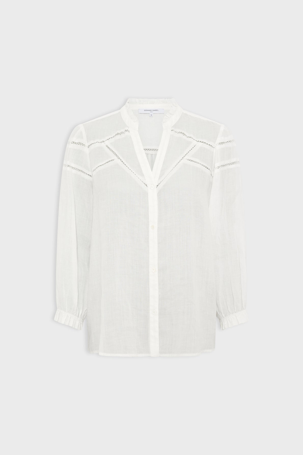 White long-sleeve blouse with a V-neckline, subtle lace details across the chest and shoulders, button-down front, and slightly gathered cuffs. The fabric appears light and semi-sheer, bringing a delicate touch of tissu transparent to the overall design.