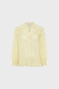 Light yellow long-sleeve chemise brodée with a v-neck, front buttons, subtle lace trim on the chest and shoulders, and elastic cuffs, crafted from tissu fin ramie and displayed on a plain white background.