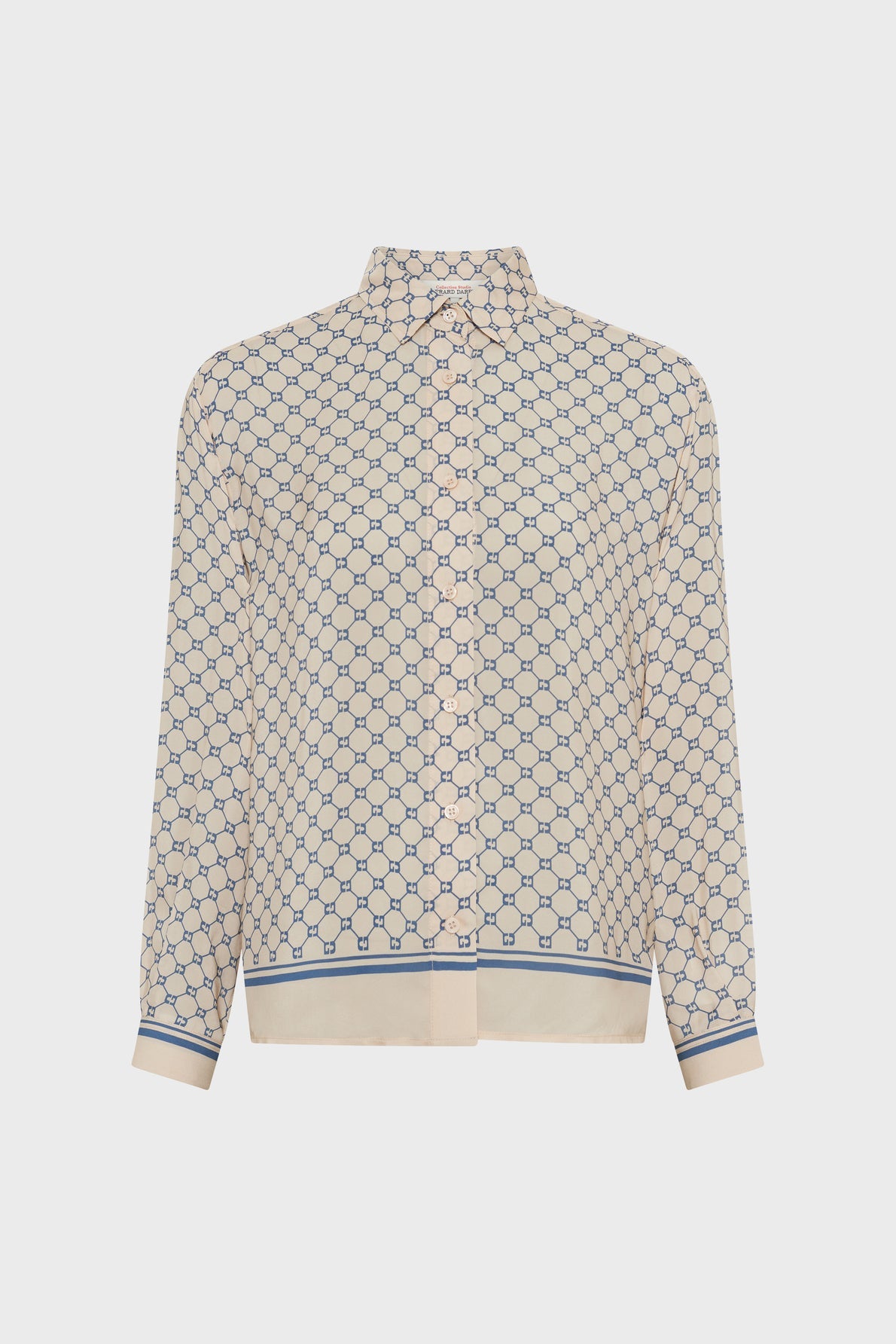 Cream-colored long-sleeve button-up blouse with a blue geometric pattern, a pointed collar, and blue-striped cuffs and hem, displayed on a plain white background—this chemise bleu écru is a chemise fluide élégante that effortlessly combines modern sophistication with timeless style.