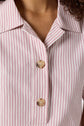 Close-up of a person wearing a chemise rayée à manches courtes with red and white vertical stripes and two tan buttons fastened, showcasing a relaxed yet stylish coupe ample.