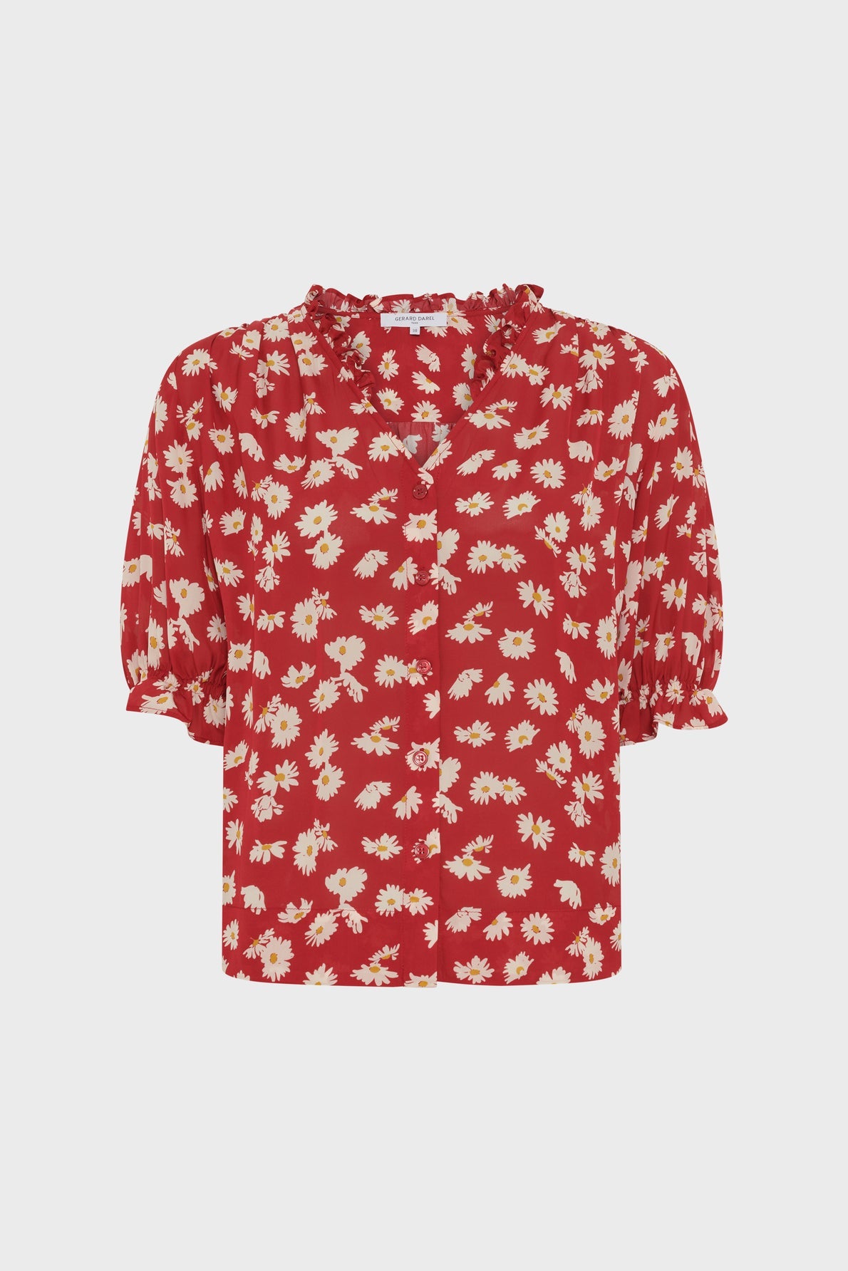 Red blouse with a white and yellow daisy print, inspired by the classic chemise fleurs style. Featuring short manches bouffantes with ruffled cuffs and a charming col volanté, this blouse has a button-down front and a loose, relaxed fit.