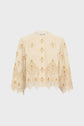 Cream-colored, long-sleeve embroidered blouse with gold floral patterns and a scalloped hem, crafted from coton seersucker for a softly textured feel, displayed on a plain white background. This édition limitée piece combines elegance and comfort in every detail.
