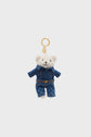 A small white teddy bear keychain, named Darel, wearing a blue denim jacket and pants, attached to a gold keyring, makes a delightful charm peluche ourson and accessoire mode against a plain light background.