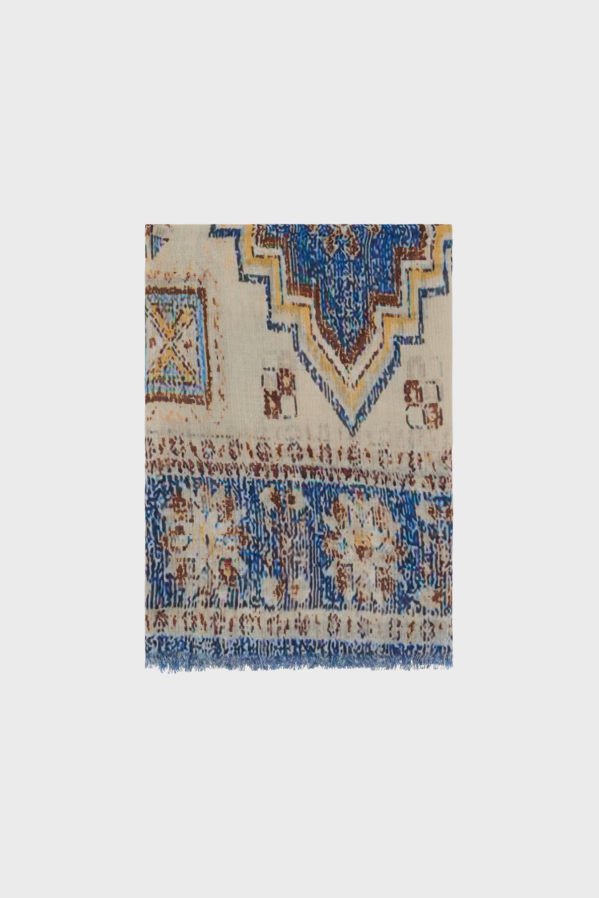 A square section of a woven rug with blue, beige, and brown geometric and floral patterns reminiscent of a motif ethnique, featuring fringed edges at the bottom—much like the intricate detailing found on an écharpe bohème or foulard Darina.