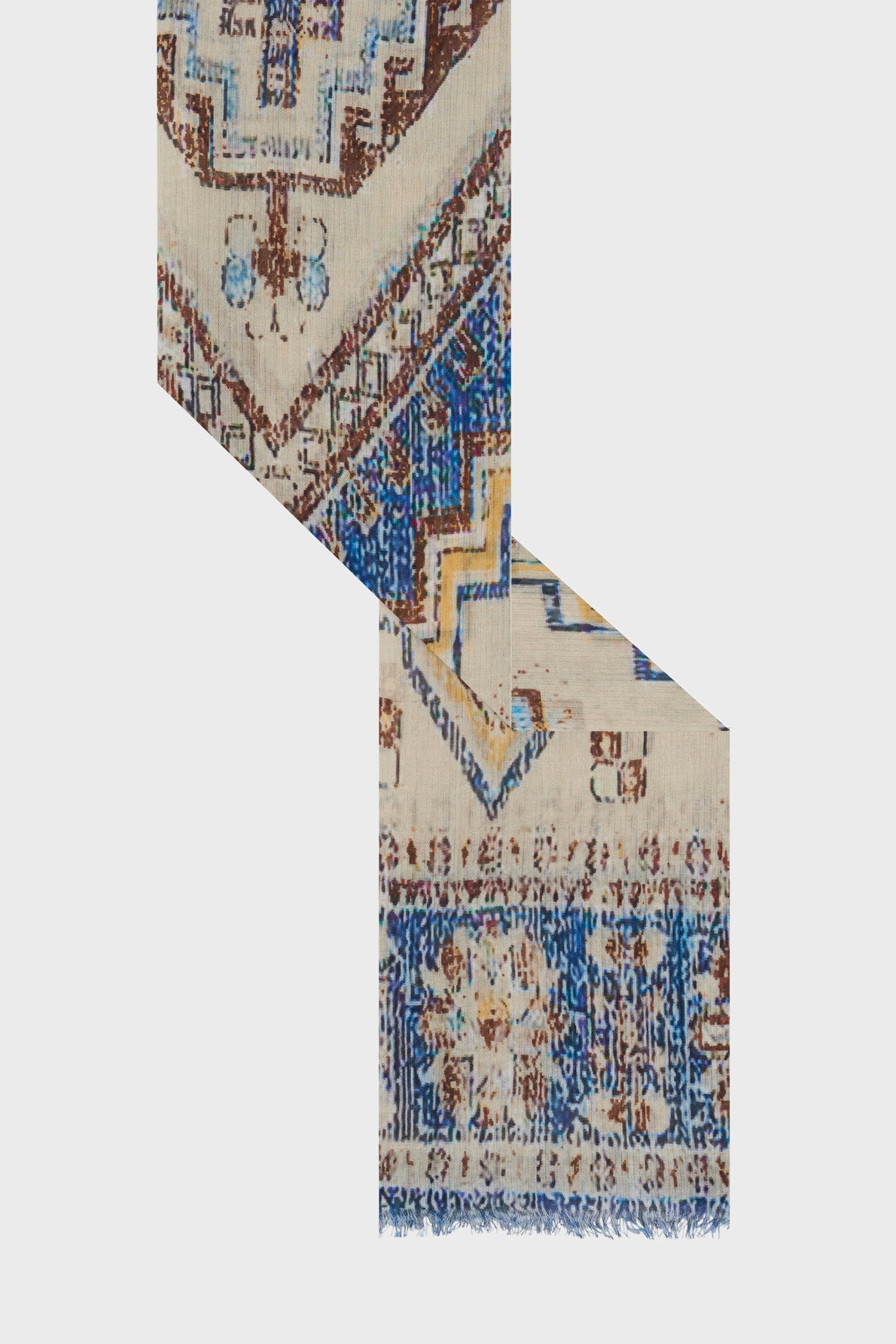 A patterned rug with geometric brown, blue, and cream designs—reminiscent of a motif ethnique—is cut and arranged in a zigzag shape against a plain light background.